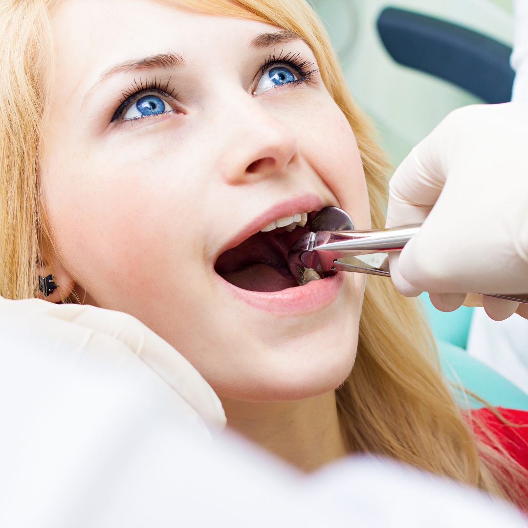 Closeup young woman having oral surgery at dentist clinic office.