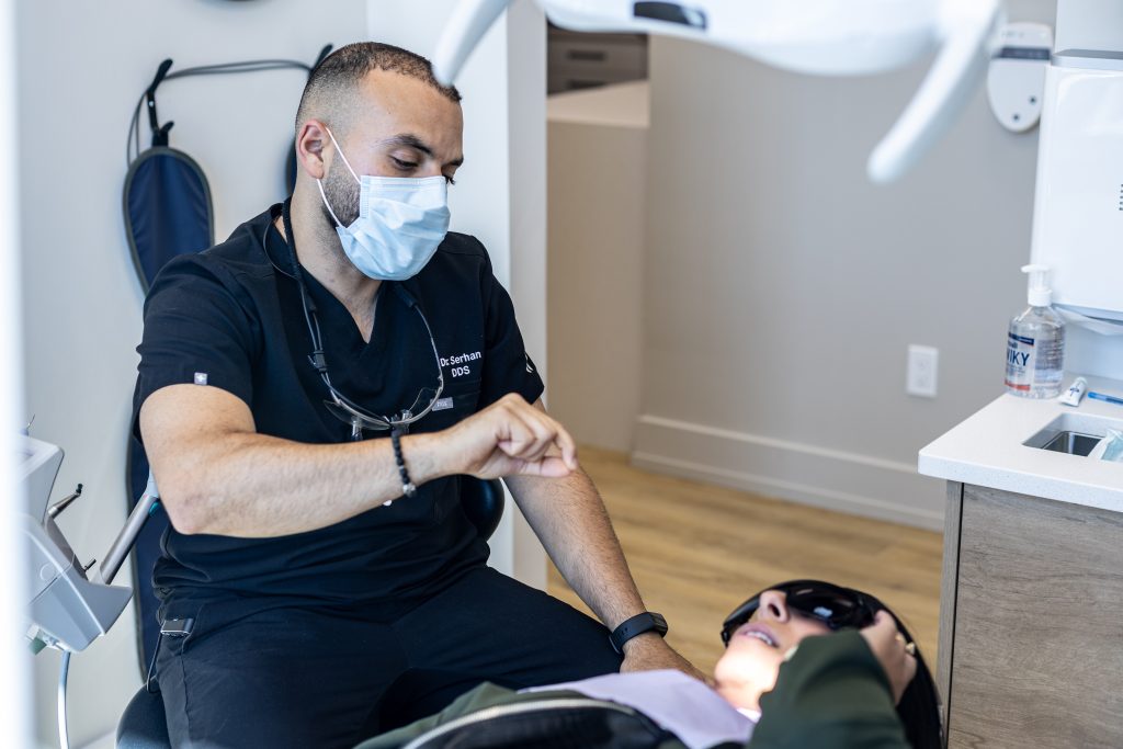 A dentist examining a patient. Contact us to book your appointment today.